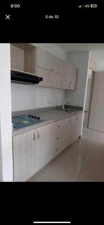 a kitchen with white cabinets and a stove top at Casa Mamajp in Medellín