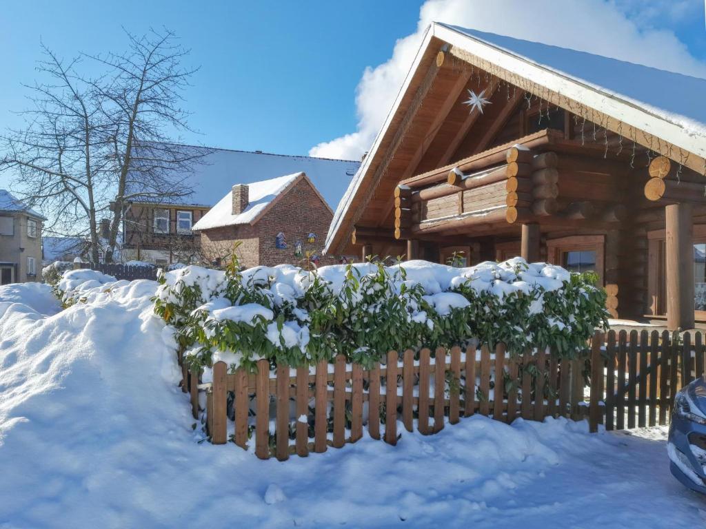 a log cabin in the snow with a fence at Ute in Dankerode