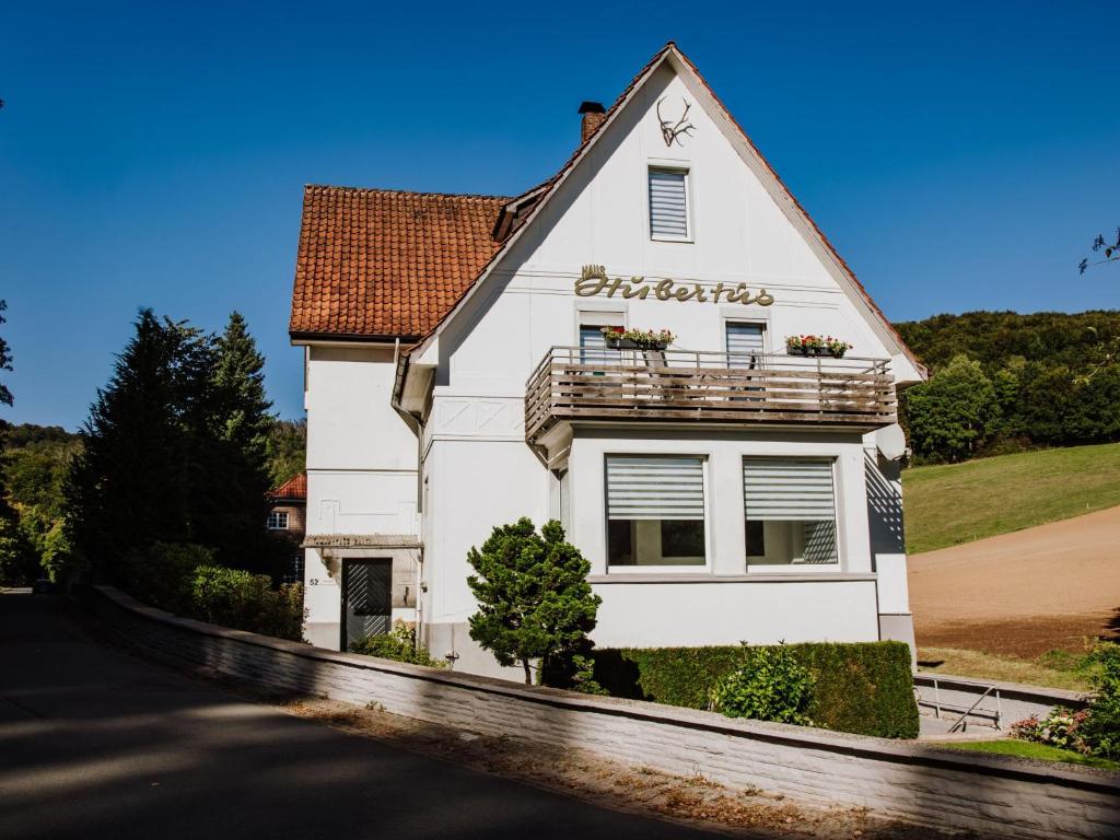 een wit huis met een balkon erbovenop bij Hubertus II in Bad Pyrmont