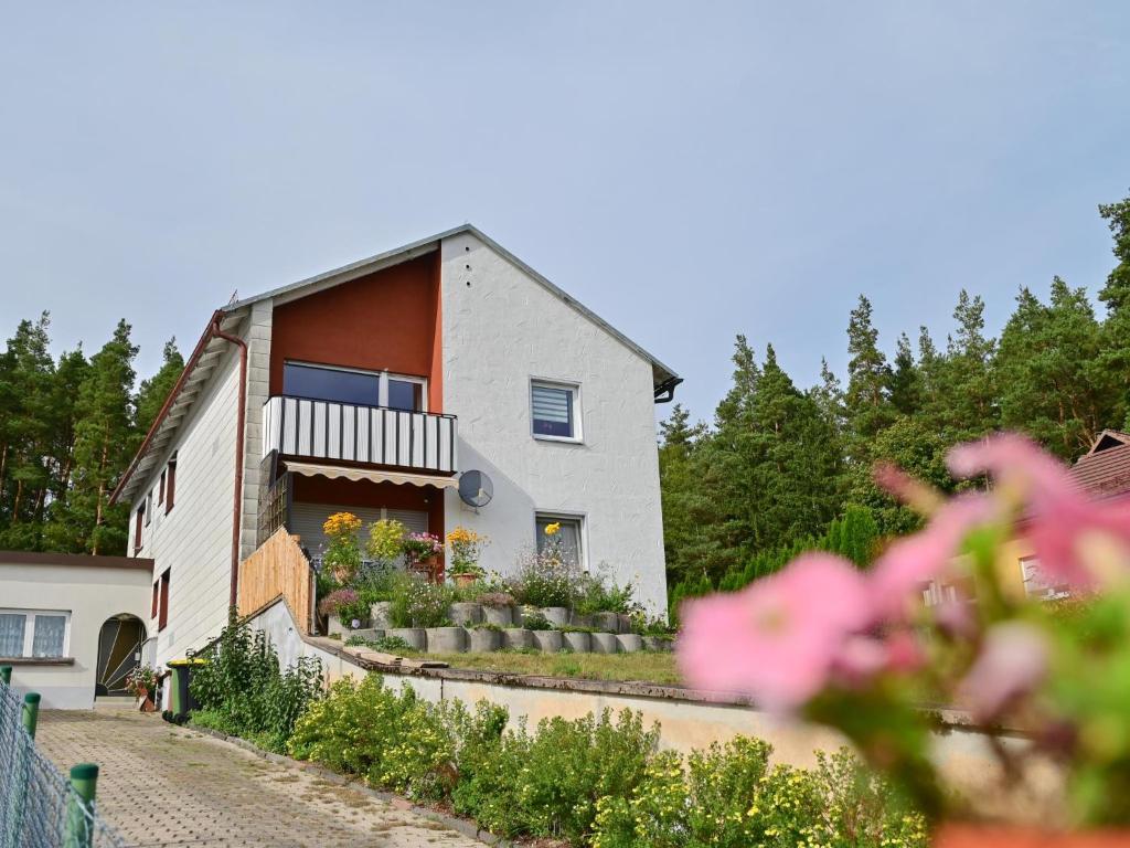 a white house with a balcony and flowers at Bärenhöhle in Marktleuthen