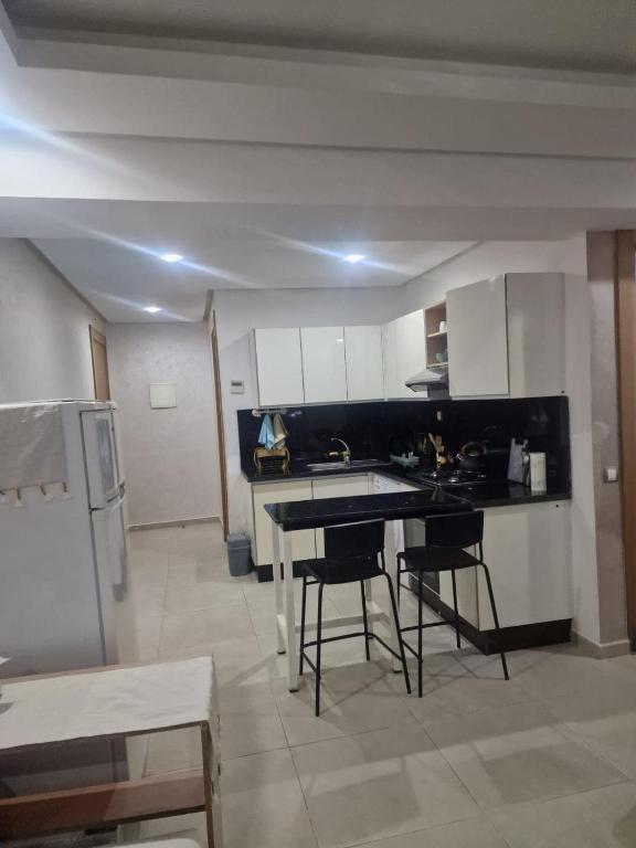 a kitchen with a table and chairs and a refrigerator at Sunny studio with a beautiful terrace in Pont Blondin