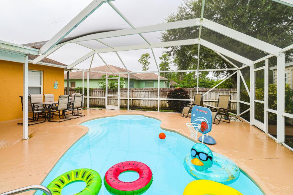 a large swimming pool with a pergola at 15 Mi to Melbourne Palm Bay Home with Pool and Lanai in Palm Bay
