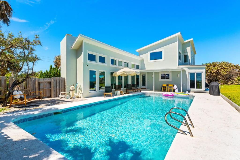 una casa con piscina delante de una casa en 5435 Highway A1A, en Melbourne Beach