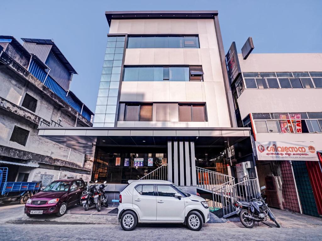 a white car parked in front of a building at Super Townhouse Edasserys Sea Pearl in Cochin