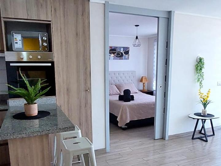 a room with a bedroom with a bed and a kitchen at Sensacional Departamento Centro - Mar 1D 1B in Antofagasta