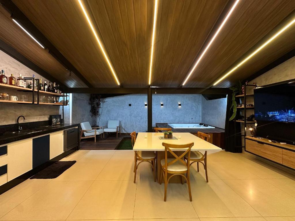 cocina con mesa y sillas y TV en Casa de condominio mobiliada Prox. MOTOGP, en Goiânia