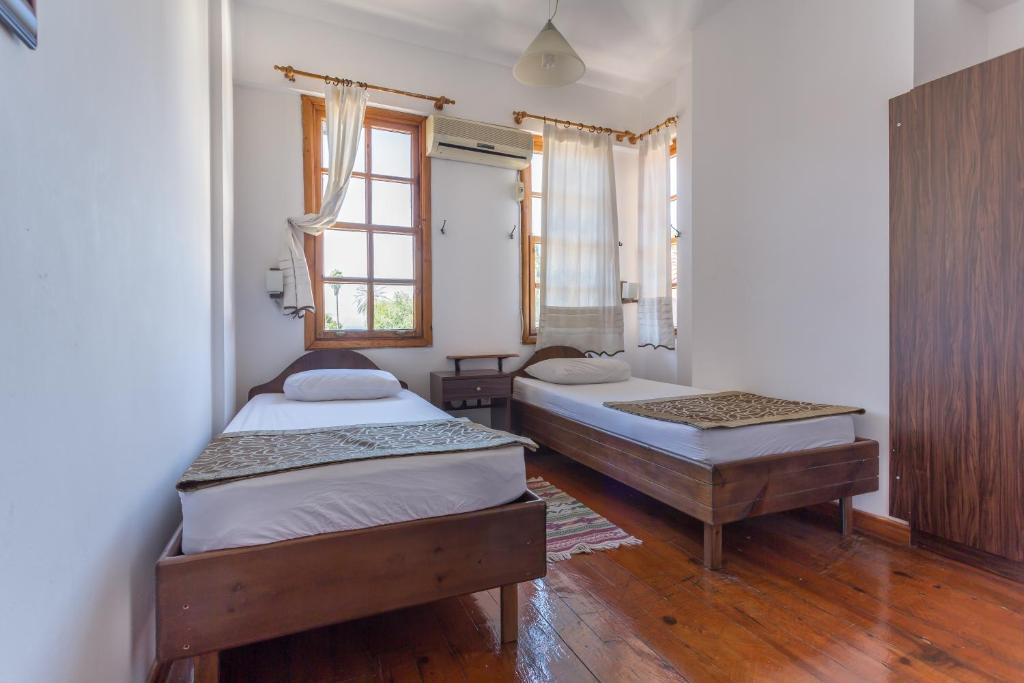 1 dormitorio con 2 camas y ventana en Mavi & Ani Pansiyon, en Antalya