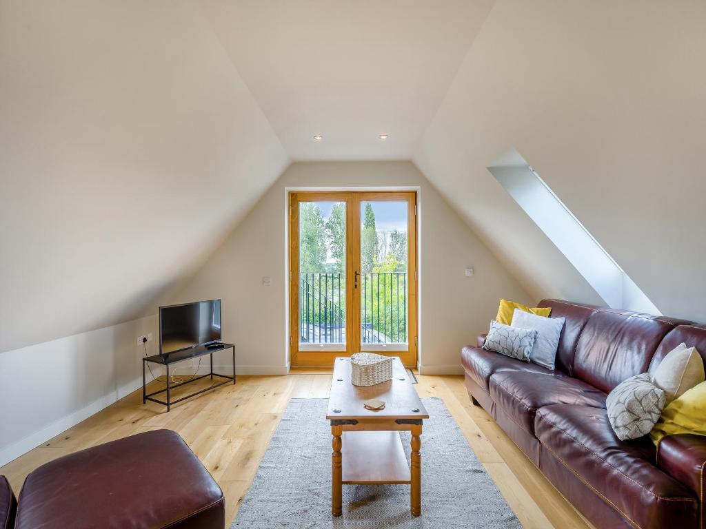 a living room with a leather couch and a table at Pond View Loft in Sudbury