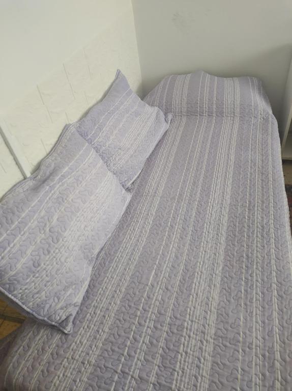 un lit avec une couette violette et un oreiller dans l'établissement Monoambiente Aldrey, à Mar del Plata
