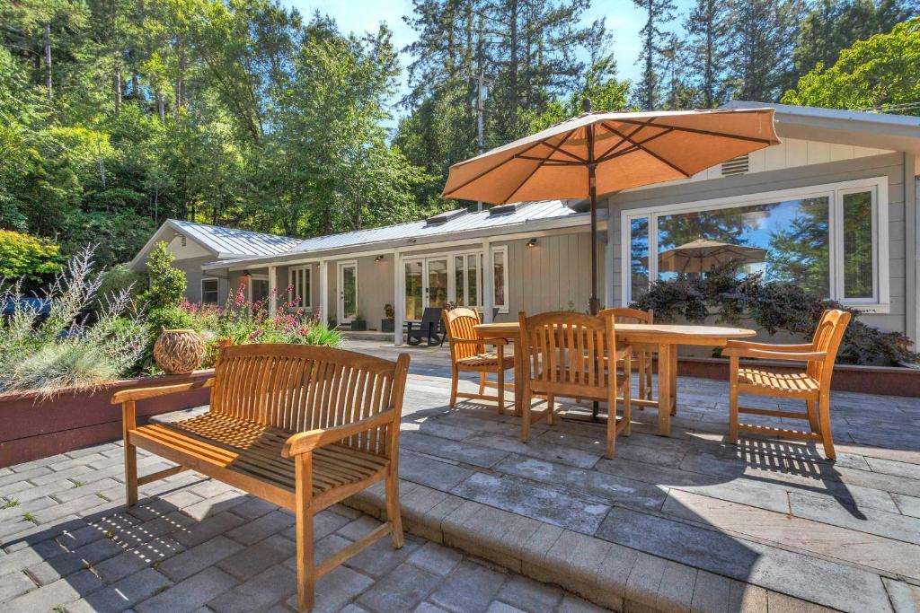 a patio with a table and chairs and an umbrella at Stylish 3BR Retreat Close to Coast & Wineries in Occidental