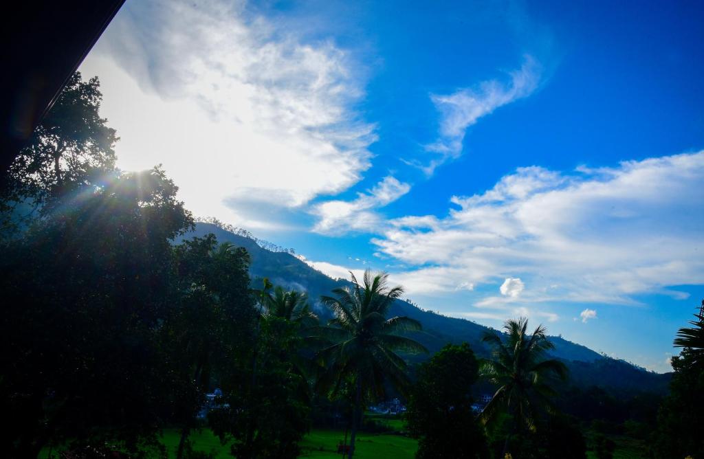 a view of a mountain with palm trees and the sun at Mountain Breeze Villa in Ella