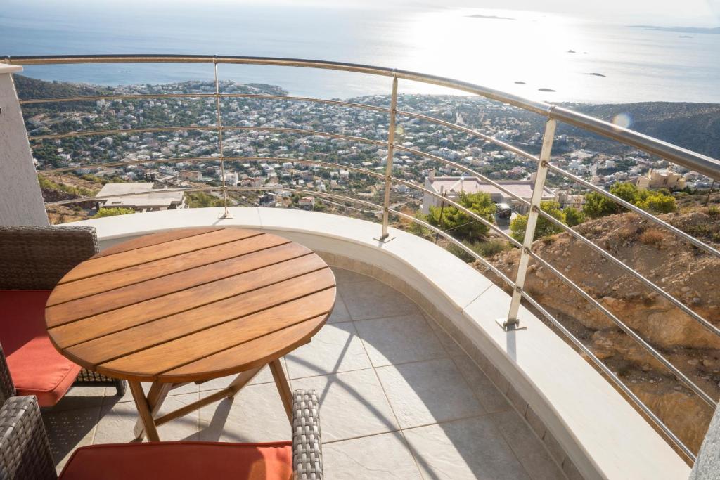 a table on a balcony with a view of a city at Viva B&B in Anavyssos