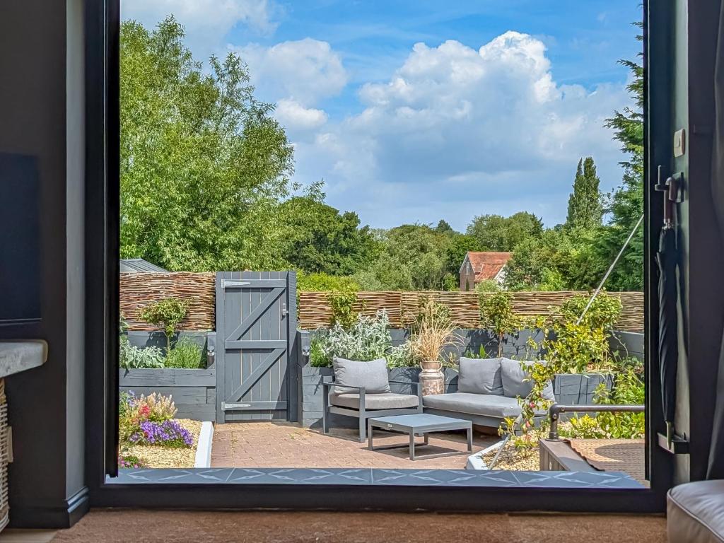 a view of a garden through a door at Little Barn in Erlestoke