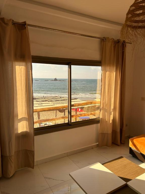 a room with a window with a view of the beach at Au Pieds dans l eau , LEGZIRA Beach in Sidi Ifni