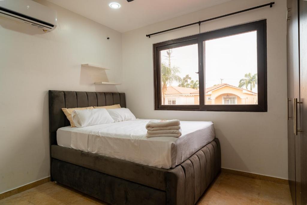 a bedroom with a large bed with a window at Via Samborondón Ciudad Celeste, Tipo Mansión, 5 camas, 4 hab, piscina gym in SamborondÃ³n