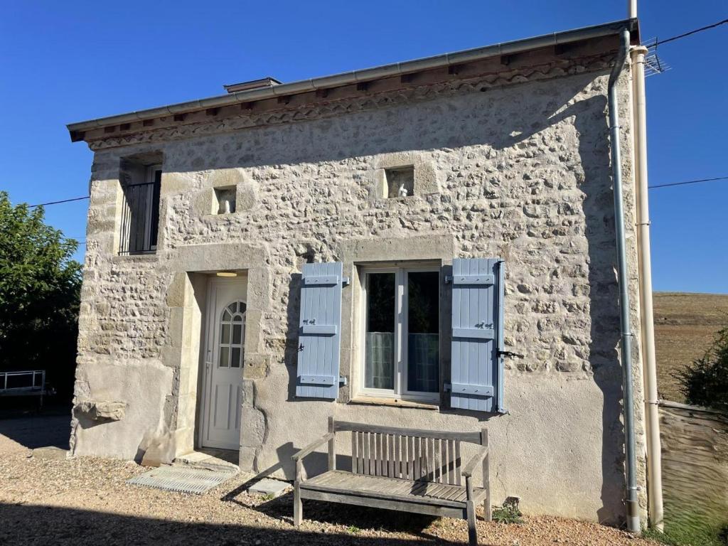 a stone house with a bench in front of it at Gîte charmant à Bellenaves, 2 pers, animaux admis - FR-1-489-595 in Valignat