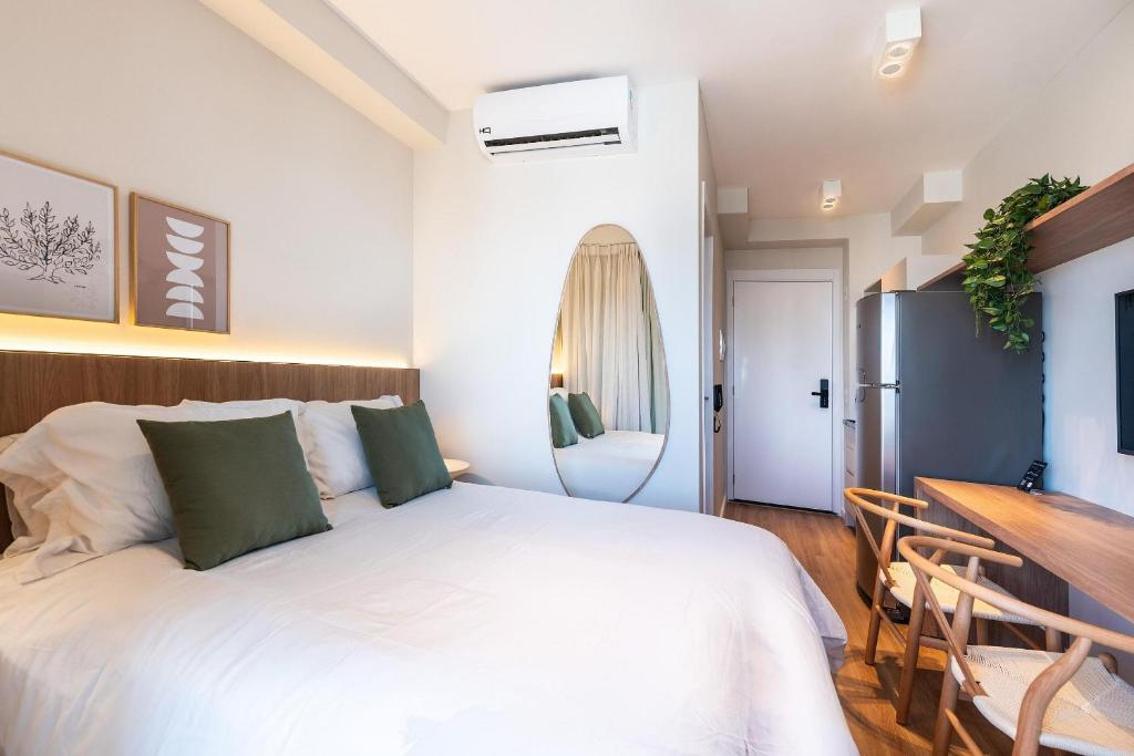 Un dormitorio con una gran cama blanca y un escritorio. en CGB1306 - Bela Vista com Piscina, en São Paulo