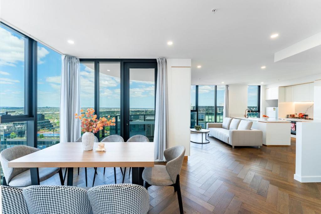 a dining room and living room with a table and chairs at Spacious 4BR penthouse in Box Hill Free Parking x 2 in Box Hill