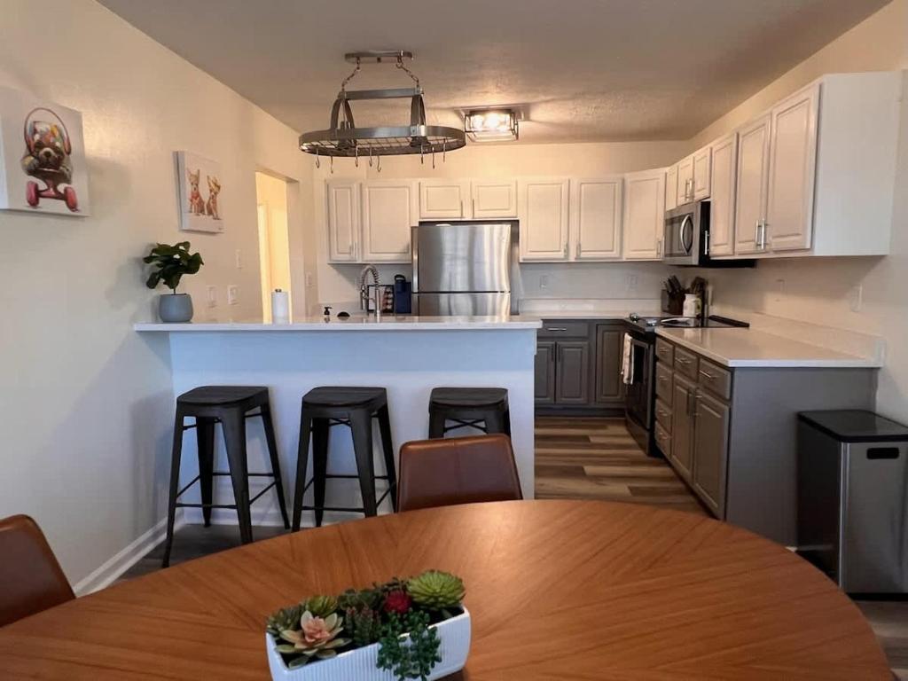 a kitchen with white cabinets and a wooden table with a tableablish at Hidden Gem Hot tub pool table - EV charger Sleep number Bed in Perry Manor