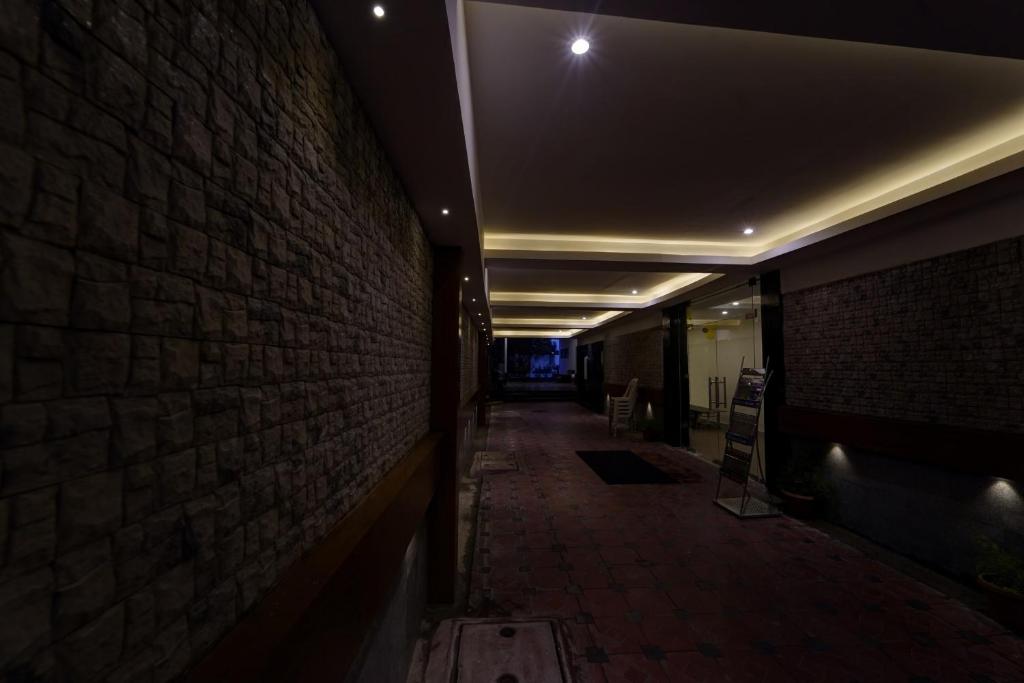 a dark hallway with a brick wall and lights at Townhouse Fantasea Hotels Near OMR in Chennai
