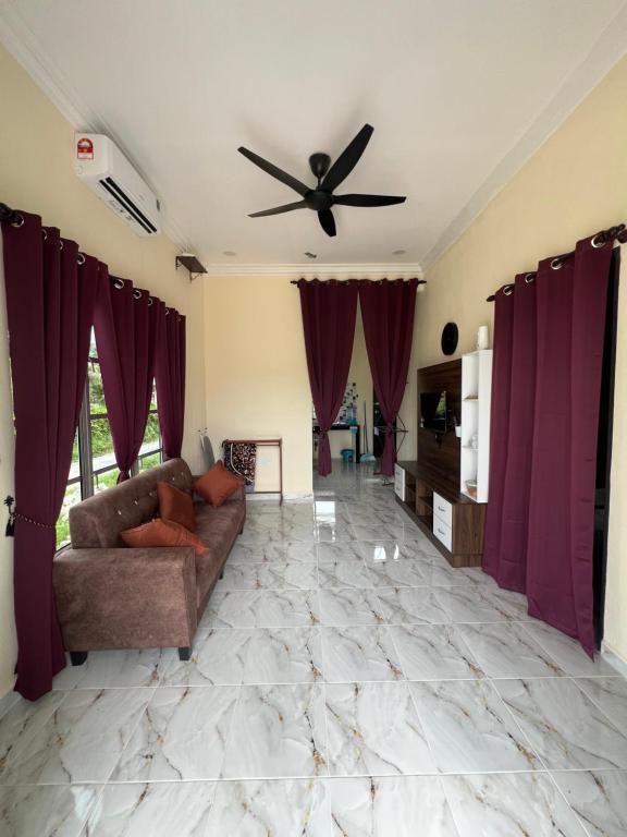 a living room with a couch and a ceiling fan at Adam Hawa Homestay Bachok in Bachok