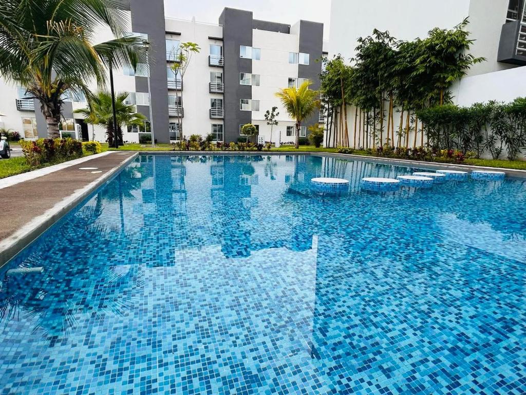 een groot blauw zwembad voor een gebouw bij El paraíso del descanso in El Jobo