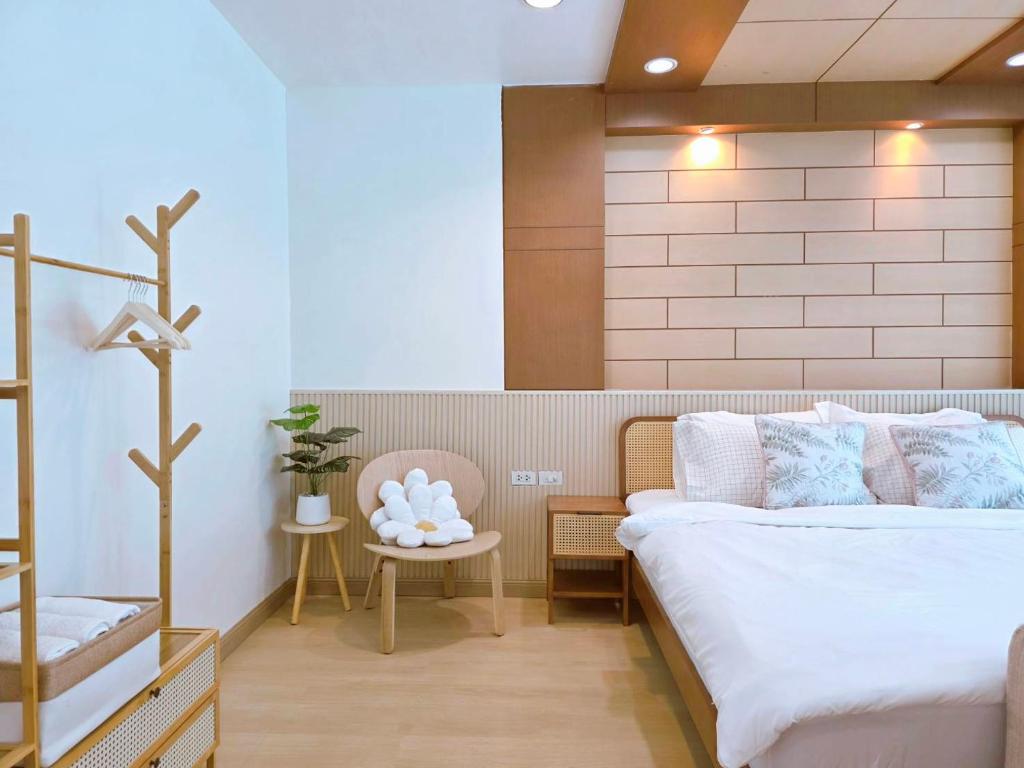 a bedroom with a bed and a table with a chair at The beach bangsaen condo daily room Poolside in Ban Bang Saen (1)