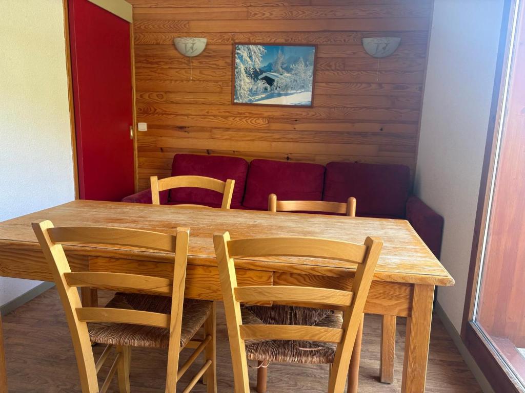 a wooden table with four chairs and a couch at Appartement 2 chambres aux pieds des pistes, parking gratuit - FR-1-807-125 in Saint-François-Longchamp