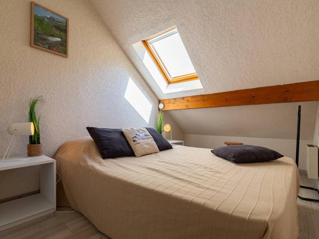 ein Schlafzimmer mit einem großen Bett mit Dachfenster in der Unterkunft T3 lumineux pour 6 personnes au cœur de Saint-Lary - FR-1-296-526 in Saint-Lary-Soulan