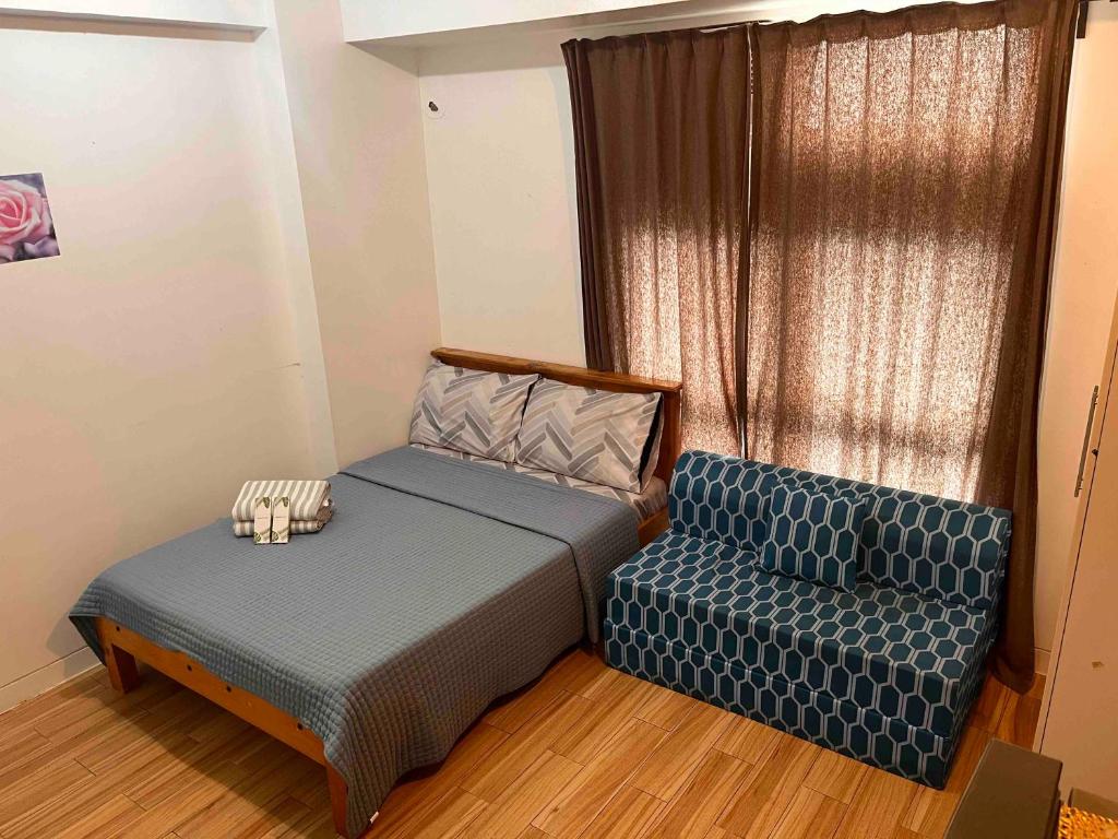 a small bedroom with a bed and a couch at JFam Suites, C3-11D Studio, Up To 4 Pax in Biñan