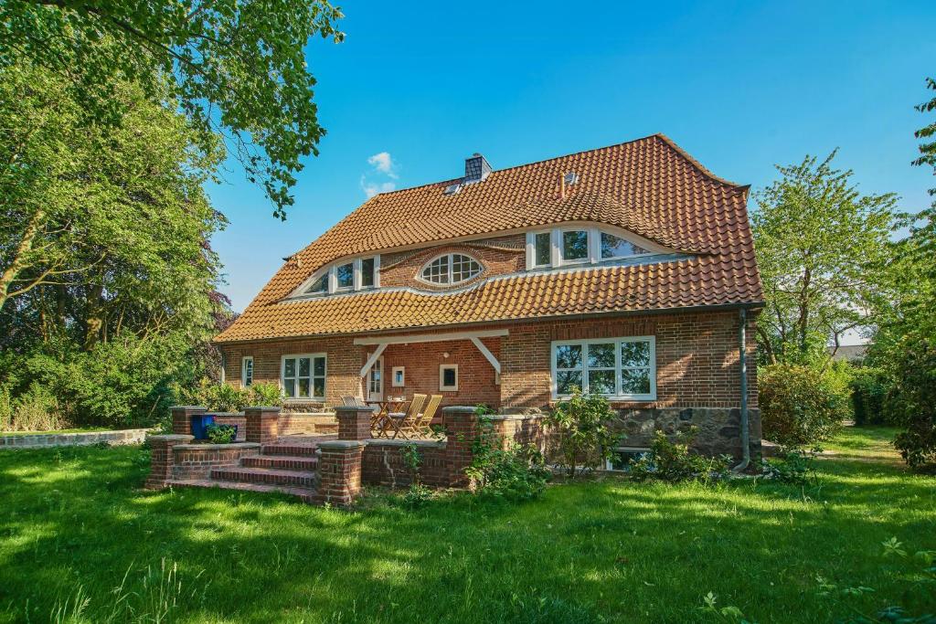 a brick house with a red roof at Artist's Studio House In Aukrug Nature Park in Meezen