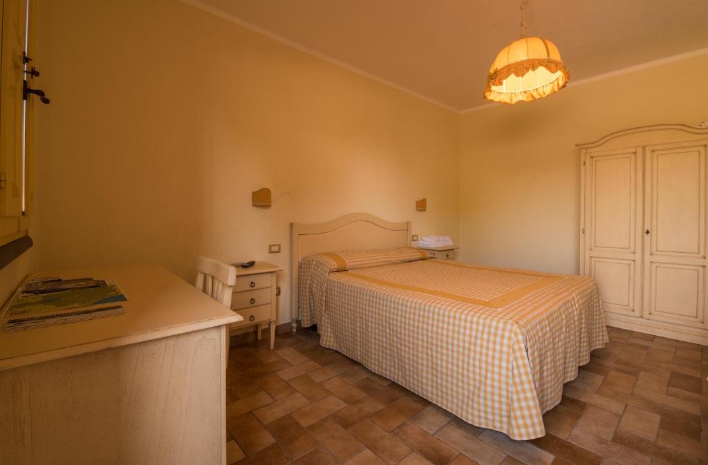 1 dormitorio pequeño con 2 camas y mesa en B&B Corte degli Struzzi, en Pescia Romana