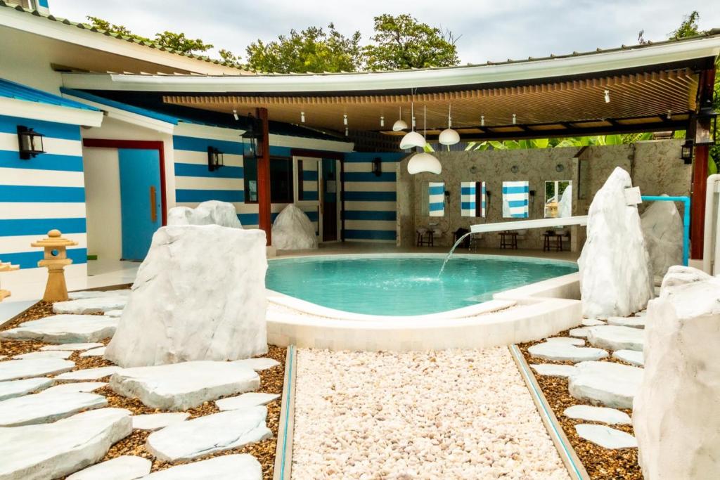 Ban Yang Pa KhaにあるChez Nij Ryokan Onsen Chiang Maiの家の隣に雪に覆われた椅子のあるプール