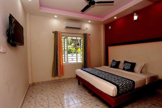 a bedroom with a large bed and a window at Premium Villas and Appartments thekady in Thekkady