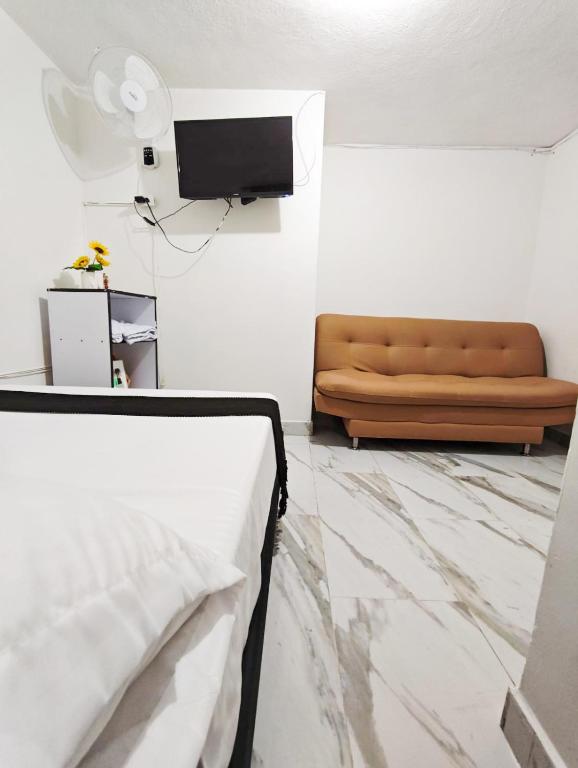 a living room with a couch and a television at Casa Eclat in Medellín