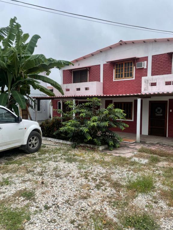 a white car parked in front of a red house at Casa del Capi in Playas