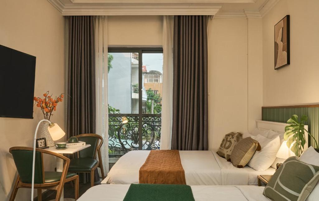 a hotel room with two beds and a balcony at The Passion Hotel Airport in Ho Chi Minh City