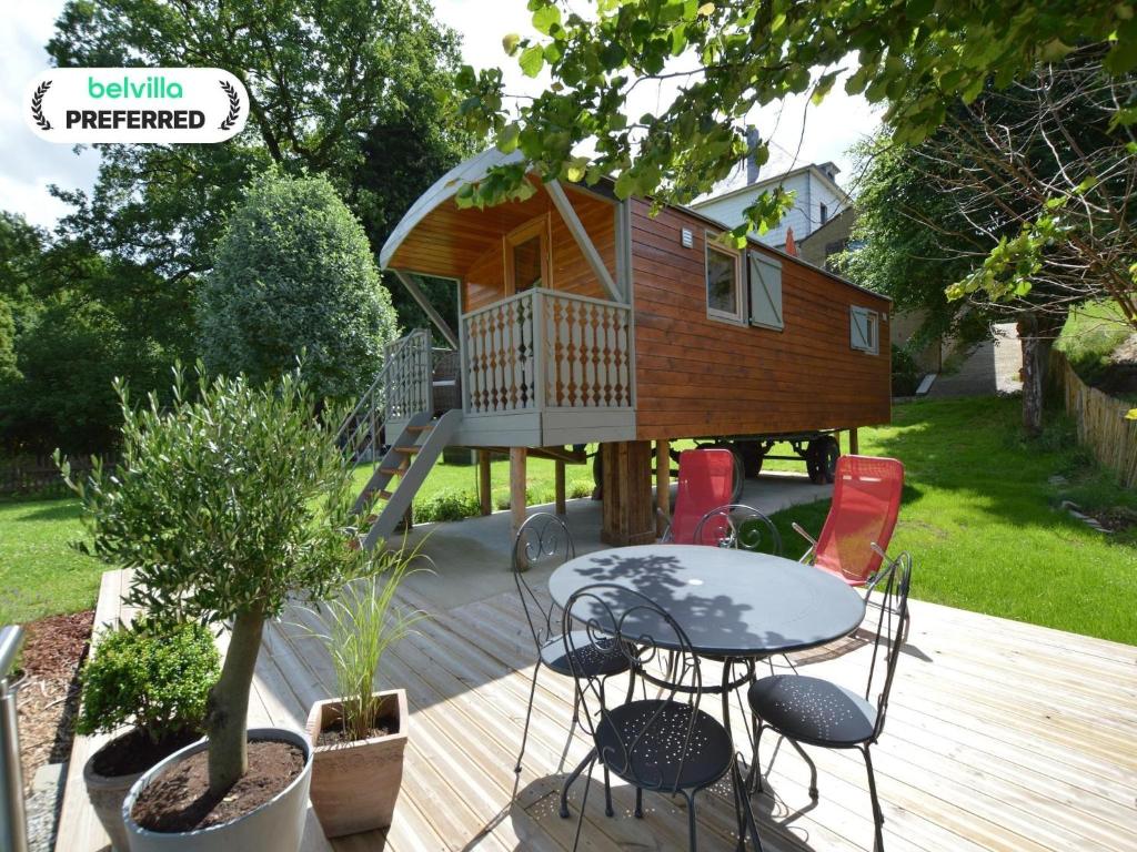 a tiny house with a table and chairs on a deck at Wellness Escape in Bellevaux in Malmedy