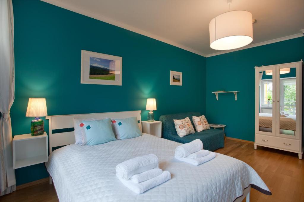 クリニツァ・ズドルイにあるTrzy Siostryのベッドルーム1室(青い壁の大きな白いベッド1台付)