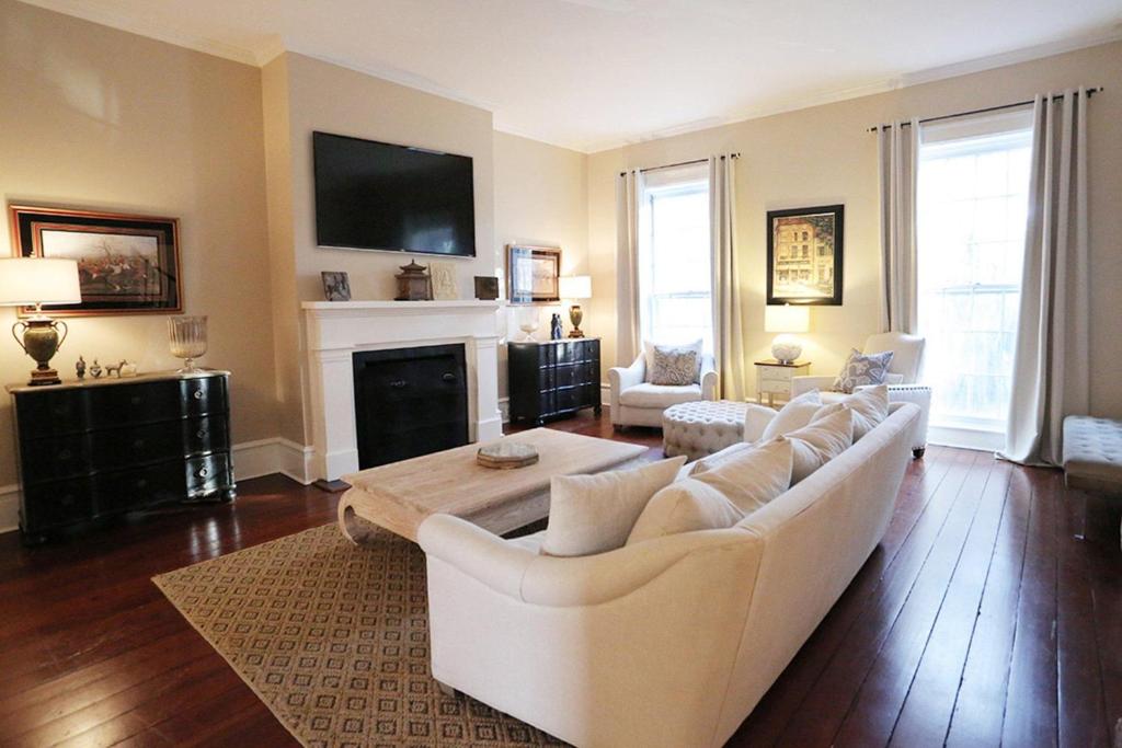 a living room with a white couch and a fireplace at Oglethorpe Estate in Savannah