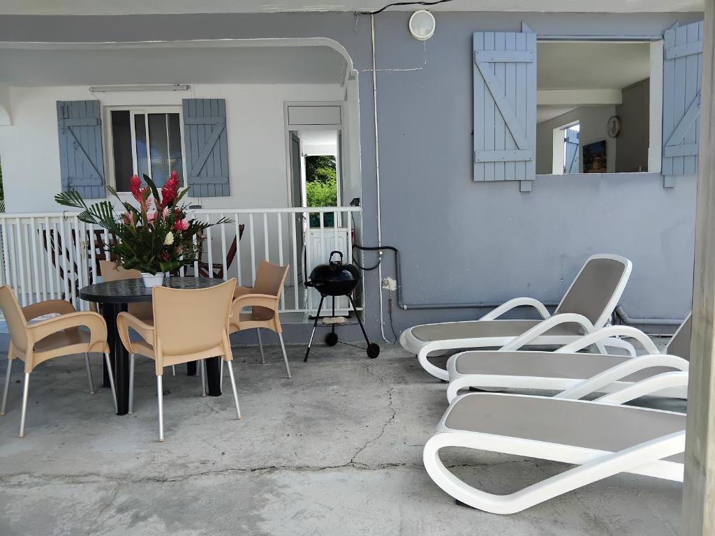 un grupo de sillas y una mesa con flores en un patio en Résidence belle place, en Saint-François