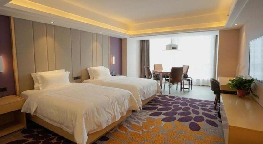 a hotel room with two beds and a dining room at Lavande Hotels· Yueyang Linxiang Zhongfa in Linxiang