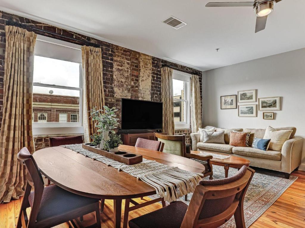 una sala de estar con una mesa y un sofá en Above Broughton St 3002, en Savannah