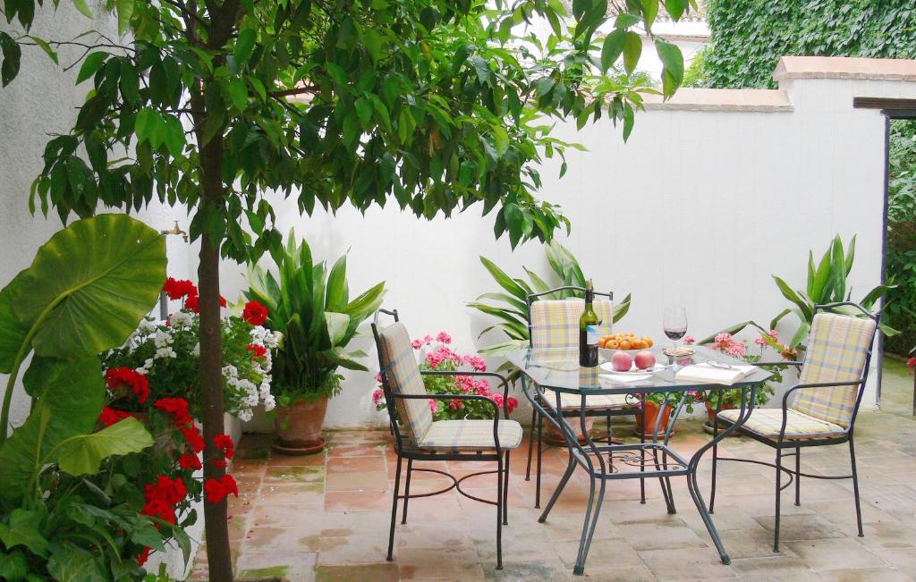 un patio con mesa, sillas y flores en La Casita del Corralon en Granada