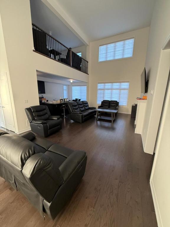 a large living room with leather couches and chairs at Modern Bay Vista Getaways in Carrying Place