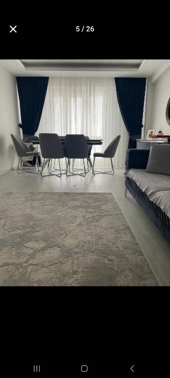 een woonkamer met een tafel, stoelen en een bank bij Eğlence Dairesi 