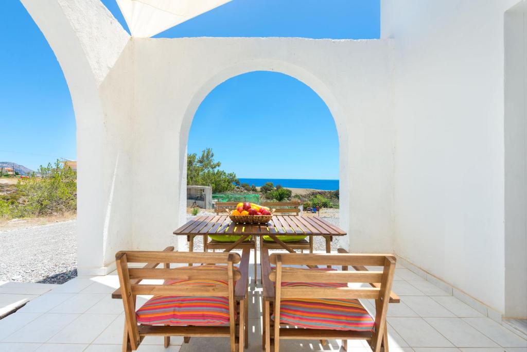 un tavolo e sedie su un patio con vista sull'oceano di Ciel Blue Villas a Kiotari
