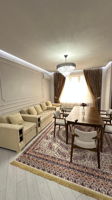 a living room with a couch and a table at Жк Тенгри in Shymkent