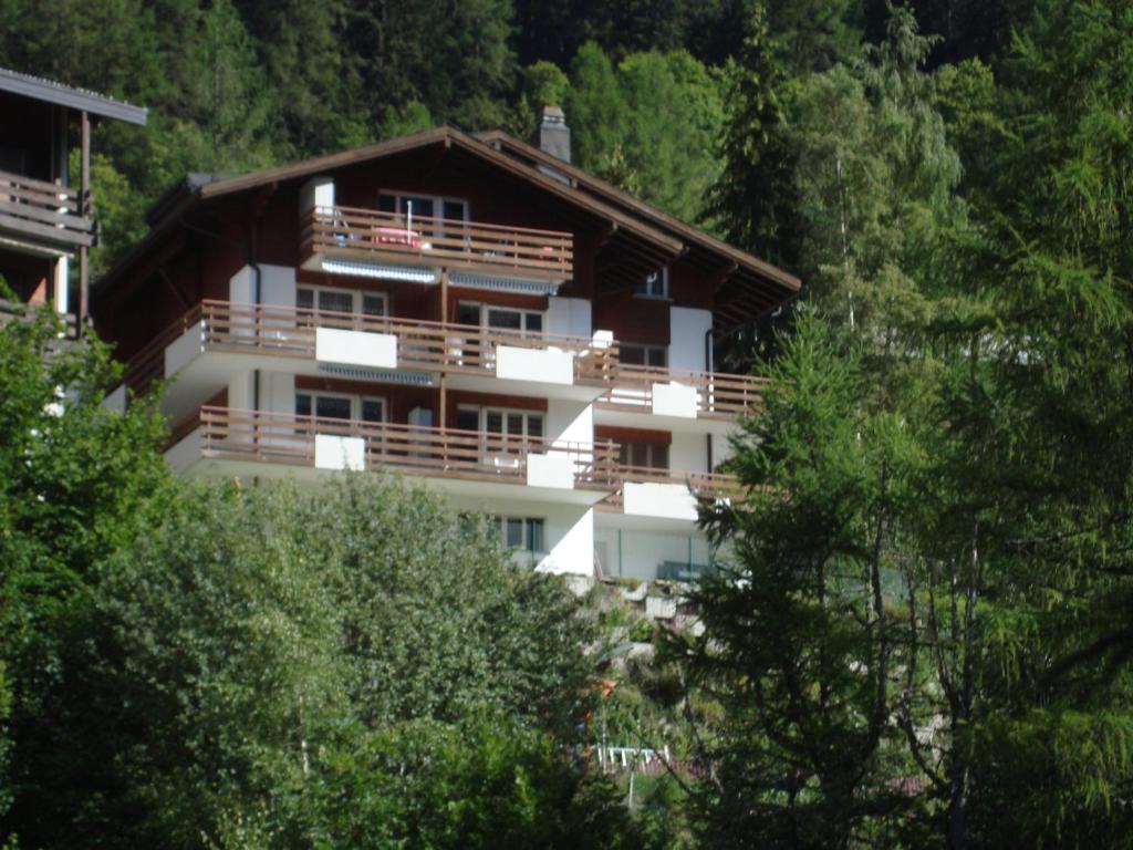 a large white building with trees in front of it at Apartments Weid in Leukerbad