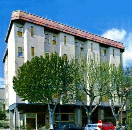 ein großes weißes Gebäude mit Bäumen davor in der Unterkunft Hotel Napoleon in Rimini